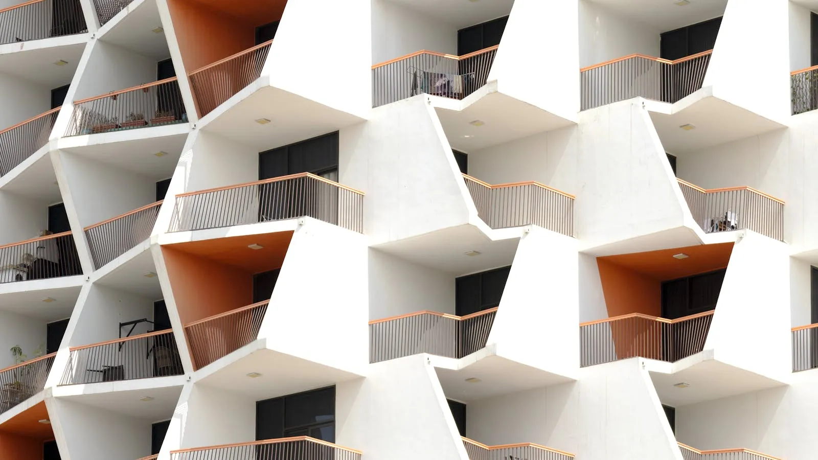Geometric modern apartment facade in Dubai showing repeating unit balconies, symbolizing the property portfolio being prepared for DET licensing